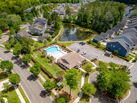 Aerial view of Bolton’s Landing homes, community pool, pond, and landscaped streets